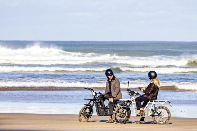 man and women riding mopeds on a beach in San Diego