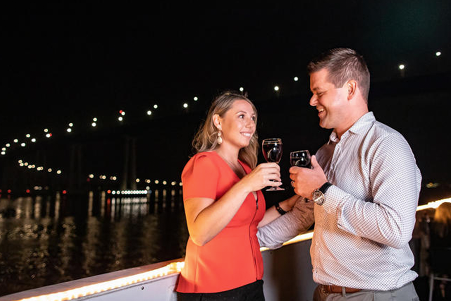 couple sharing a cheers on a harbor dinner cruise