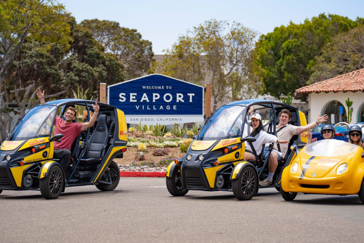 3 GoCars in front of the Seaport Village sign in San Diego