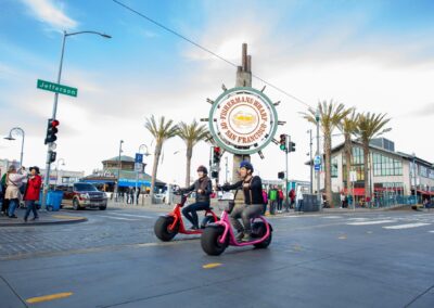 two people on electric fat tire scooters in fisherman wharf san francisco