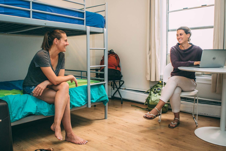 two women sitting in one of the shared bunk rooms in HI hostel's downtown San Diego location