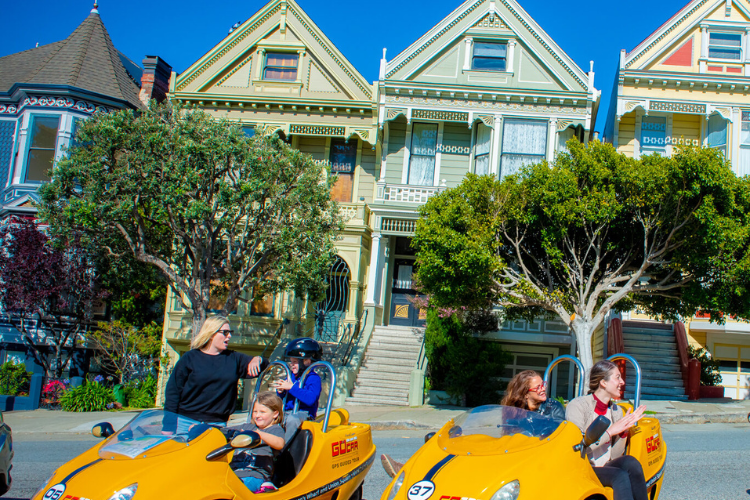 two GoCars parked in front of colorful houses in the Haight-Ashbury neighborhood