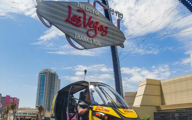 Person sitting in a GoCar under Las Vegas Sign